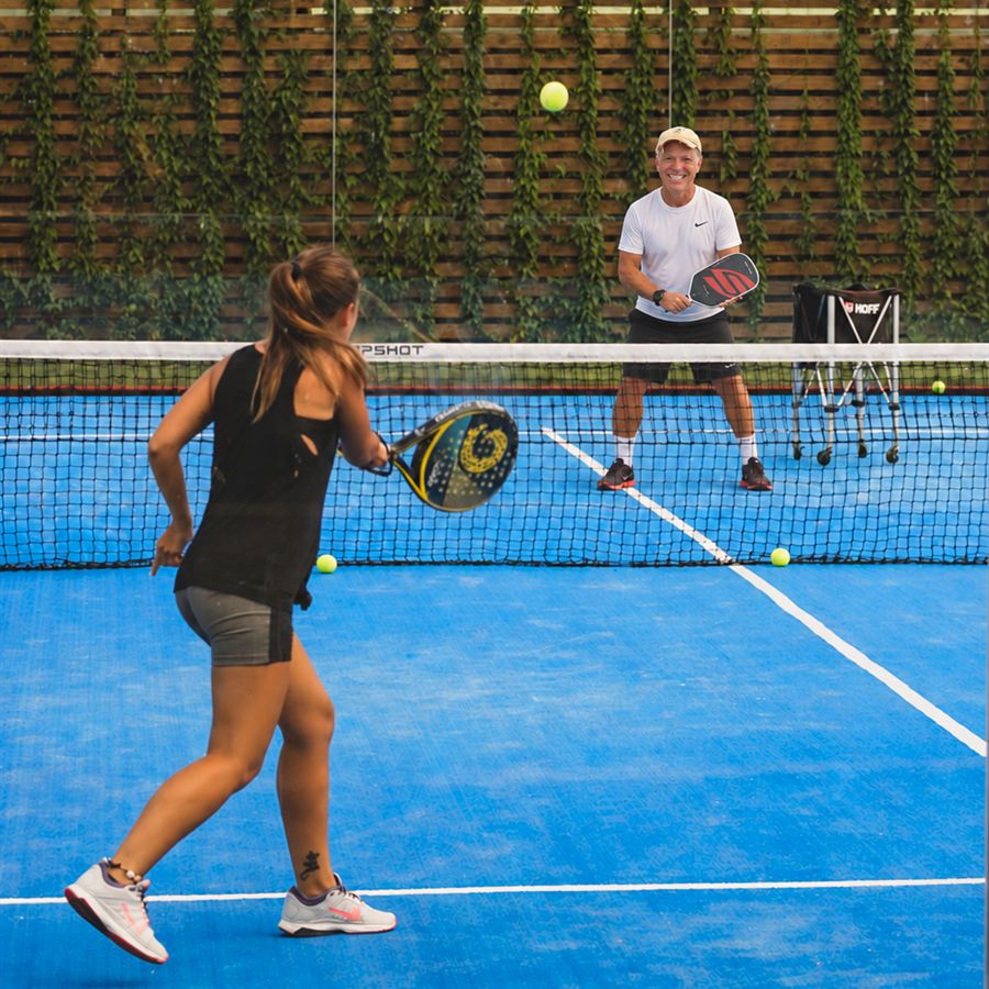 A player moving through a rally with Coach Henry across the net